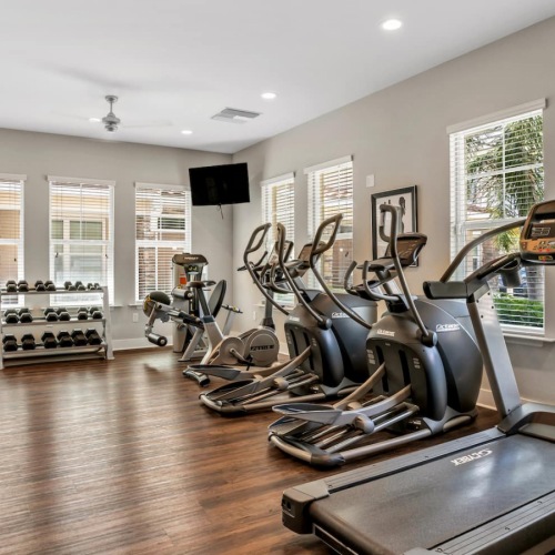 fitness center rendering showing plenty of equipment and modern decor in a large, spacious room